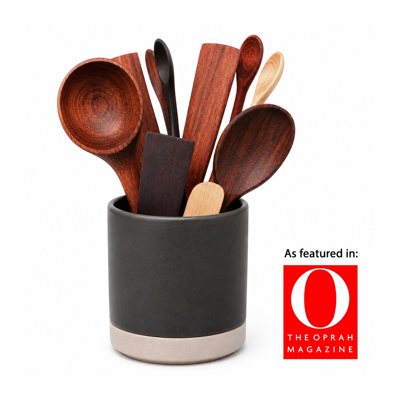 Set of wooden spoons in a green ceramic holder on a kitchen counter.