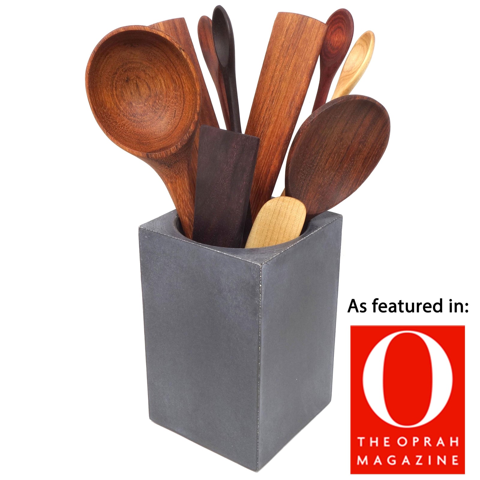 Set of wooden spoons in a green ceramic holder on a kitchen counter.